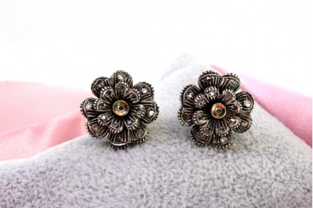 Par de brincos circular em ouro e prata com lascas de diamante em forma de flor.