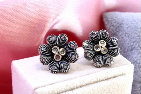 Par de brincos em ouro e prata com lascas de diamante em forma de flor.