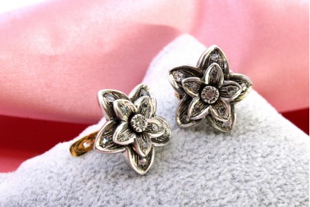 Par de brincos em ouro e prata em forma de flor com lascas de diamante.
