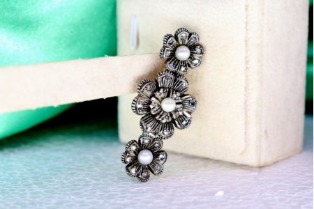  Pregadeira em ouro e prata em forma de flores com lascas de diamantes e três pérolas de cultura no centro.