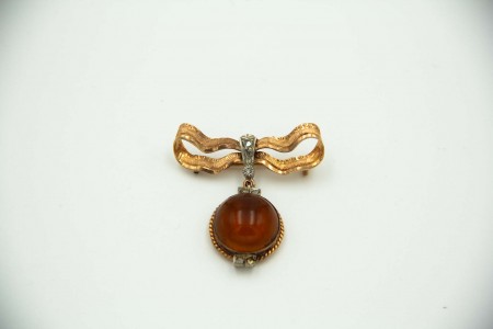 Pregadeira de ouro e prata em forma de laço com lascas de diamante e cabochão de