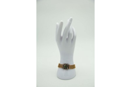 Pulseira de ouro com elos articulados, esmeralda e diamantes aplicados no fecho.