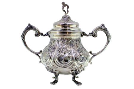 Açucareiro em prata relevada com motivos florais, folhas de acanto e assente sobre quatro pés em forma de garras.