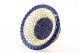Aneleira de porcelana recortada em tons de azul e creme, com base circular em prata dourada.