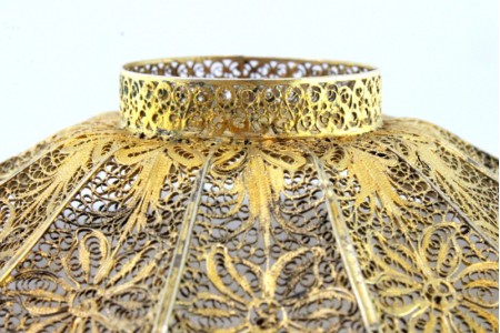 Aneleira em prata dourada de filigrana com relevos assente em base redonda.