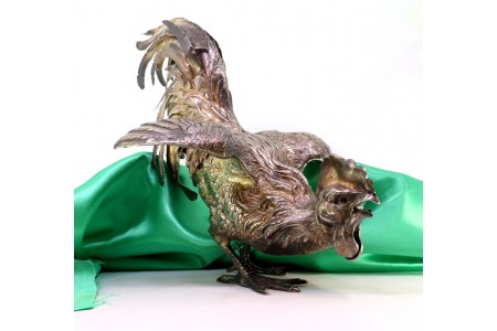 Par de galos de luta em prata com relevos e aplicações.