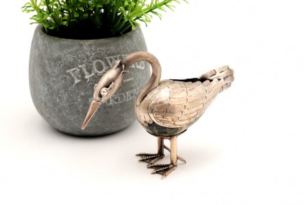 Pássaro em prata com relevos e aplicações e sobre pedra dura.