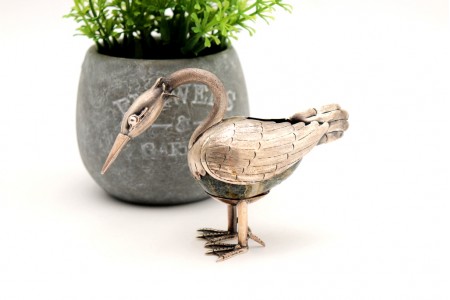 Pássaro em prata com relevos e aplicações e sobre pedra dura.