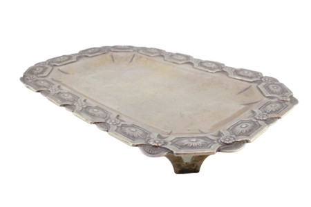 Bandeja em prata em forma retangular de cantos cortados e relevos florais na envolvência, assente sobre quatro pés vazados.