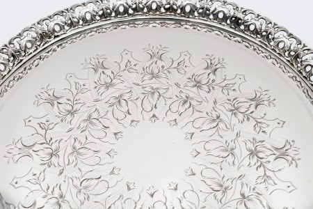 Bandeja em prata com gradinha recortada e gravação de motivos vegetalistas assente em três pés em forma de garras