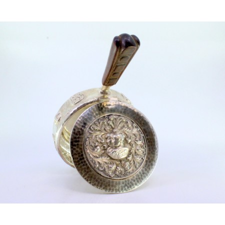 Beateira em prata com relevos e busto de soldados romanos na tampa martelada, relevos na envolvência e pega em madeira.