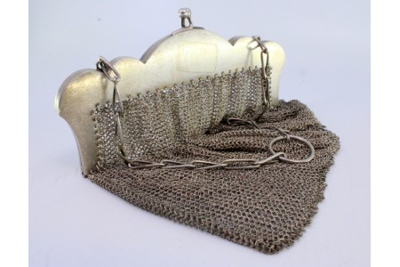 Bolsa de mão em prata com aplicação no arco de motivos florais ao estilo filigrana e corrente em malha aberta.