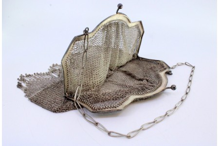 Bolsa de mão em prata com franjas e arco liso com corrente em malha de argola larga.