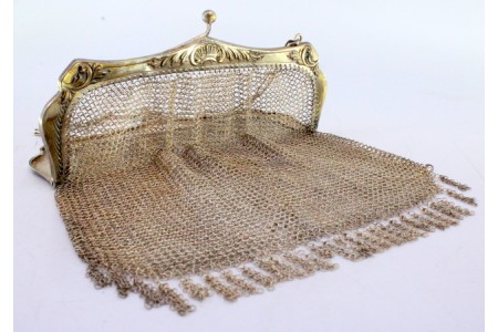 Bolsa de mão em prata com franjas suspensas com relevos no arco e corrente em malha cadeado.