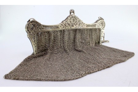 Bolsa de mão em prata de malha dupla recortada no arco com grinaldas, motivos florais e corrente em malha cadeado.