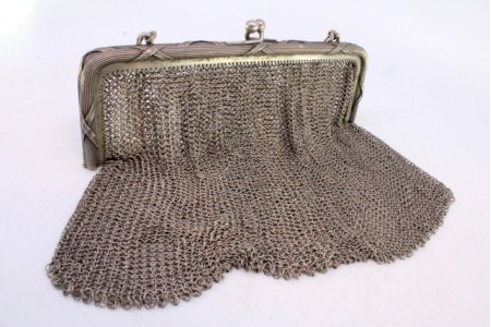 Bolsa de mão em malha de prata com arco frisado e relevado, corrente em forma cadeado.