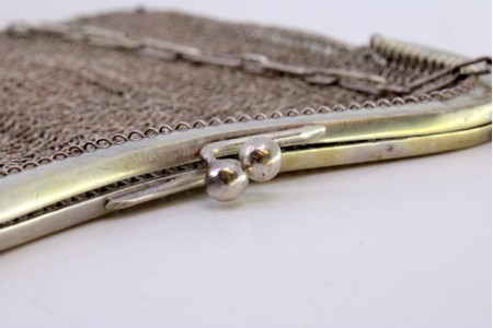  Bolsa de mão em malha de prata com franjas suspensas, arco liso e corrente em malha cadeado.