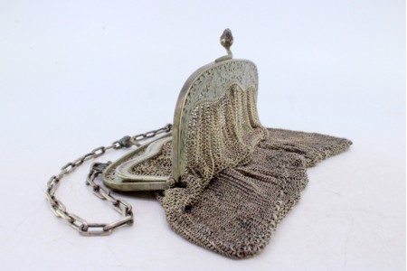 Bolsa de malha em prata pequena com topo recortado com fecho em forma de bolotas e corrente