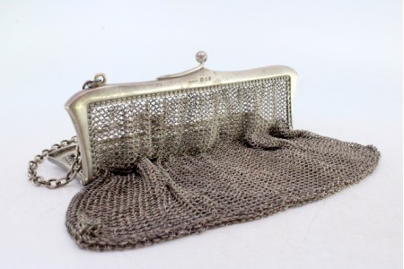Bolsa de mão em malha de prata com arco liso e corrente em malha cadeado.