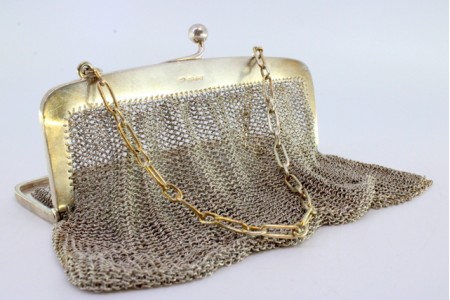 Bolsa de mão em malha de prata dupla com arco liso e corrente em malha cadeado.