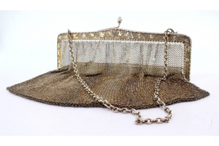 Bolsa de mão em malha de prata com motivos relevados no arco e corrente em malha cadeado.