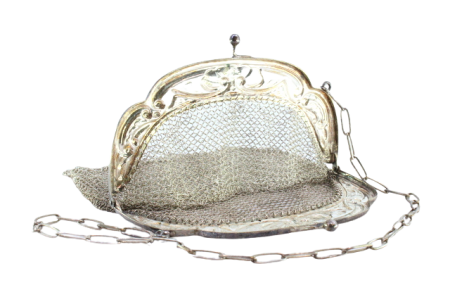 Bolsa de mão em malha de prata com fantasias, gravados e concheado no arco, franjas em suspensão e corrente de transporte.