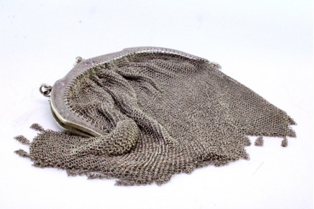 Bolsa de mão em malha de prata com arco relevado,  franjas pendentes e corrente em malha cadeado.