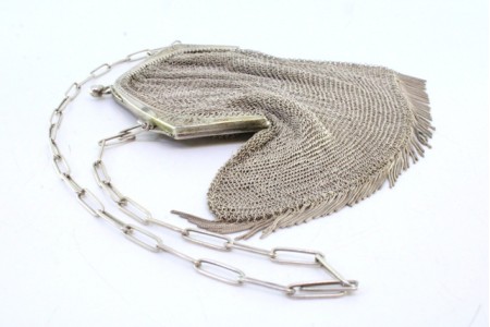 Bolsa de mão em malha dupla de prata com franjas e arco relevado, com corrente em malha cadeado.