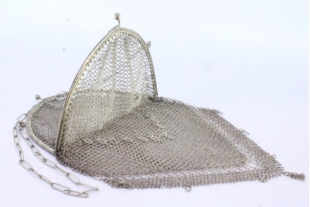 Bolsa em malha de prata com franjas pendentes, arco ao estilo gótico e corrente em malha cadeado.