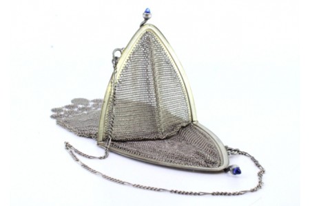 Bolsa de mão em malha de prata com franjas pendentes com dois cabochões azuis no fecho e corrente em malha cadeado.