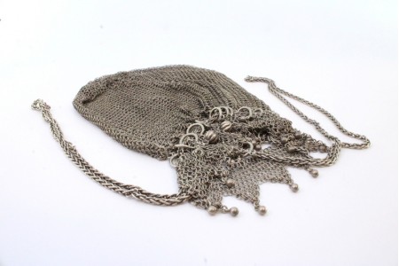  Bolsa em malha de prata com franjas e bolas suspensas e corrente corrediça em malha cadeado.