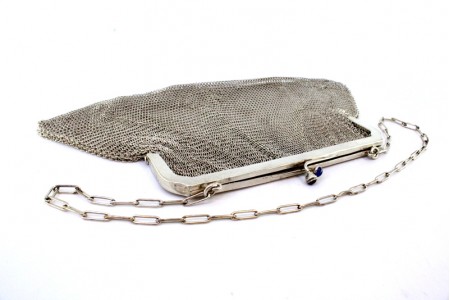 Bolsa em malha de prata com abertura com dois cabochões azuis e corrente em malha cadeado.