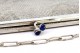 Bolsa em malha de prata com abertura com dois cabochões azuis e corrente em malha cadeado.