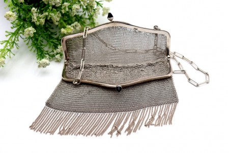 Bolsa em prata em malha com franjas suspensas, cabochões no fecho do arco liso e corrente em malha cadeado