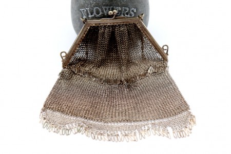 Bolsa de mão em prata com franjas e arco frisado, em malha alternada.
