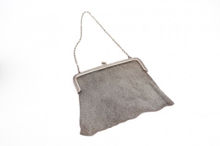 Bolsa em malha dupla de prata com arco relevado e corrente em malha cadeado.