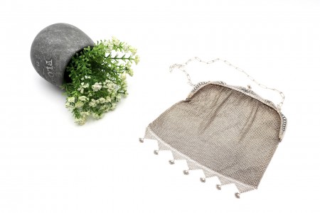 Bolsa em malha de prata com cadilhes e elementos florais relevados no arco