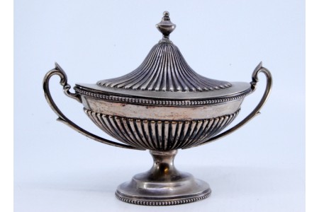  Bomboneira em prata com relevos canelados, rebordo e base com frisos, perlados e tampa amovível.