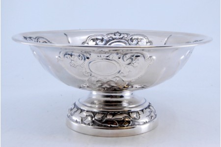 Bomboneira em prata com relevos, base redonda e motivos florais.