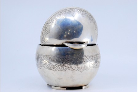 Bomboneira em prata em forma de bola com gravados concheados e motivos florais.