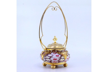   Bomboneira em prata dourada com depósito em vidro de murano relevado com motivos florais e assente sobre quatro pés em forma esférica.