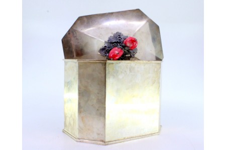 Bomboneira em prata lisa de forma octogonal com aplicação de frutos e folhas na tampa.