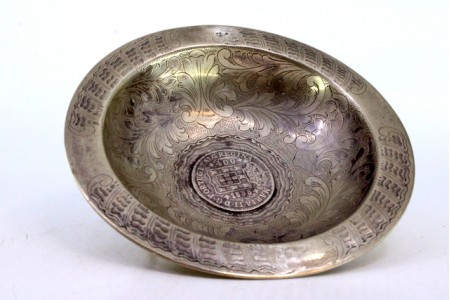 Bomboneira em prata com motivos florais gravados e moeda de 400 reis ao centro apoiada em três pés.