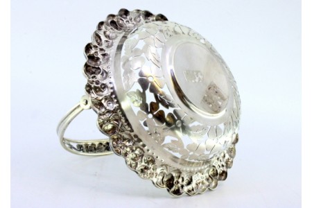 Bomboneira em prata recortada em forma de cesto com motivos florais relevados e asa articulada.