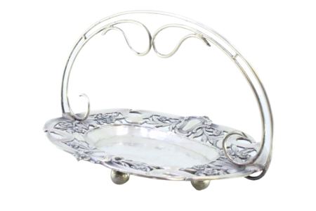 Bomboneira em prata com motivos florais recortados envolvendo cartelas para monogramas de asa fixa e assente em quatro pés em forma de bolas.