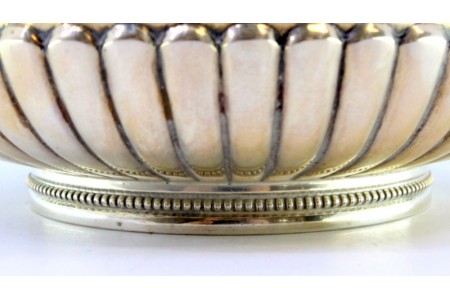 Bomboneira em prata gomada com gravados, laços, grinaldas, asas relevadas e pomo na tampa em forma de folhas de acanto.