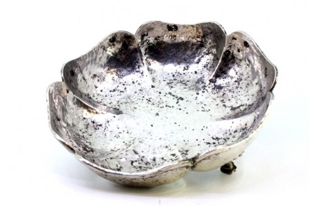 Bomboneira em prata martelada em forma de gomos e assente em três pés com caneluras.