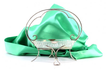 Bomboneira em vidro com estrutura em prata com enrolamentos e assente em quatro pés vasados.