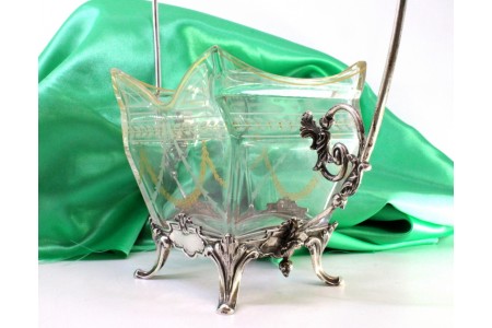 Bomboneira em vidro lapidado a ácido com bordura dourada e estrutura em prata com enrolamentos, assente em quatro pés relevados.