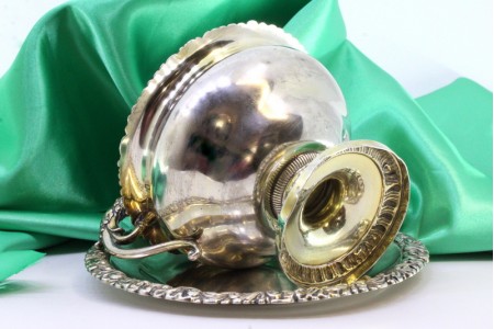 Bomboneira em prata com relevos e asa perdida em forma de leão, aplicações relevadas e assente em prato.